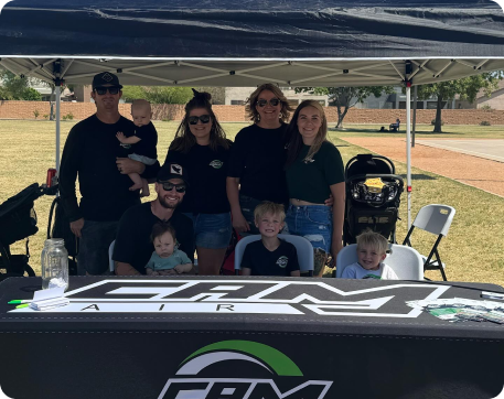 CAM Air family sitting under branded tent outside